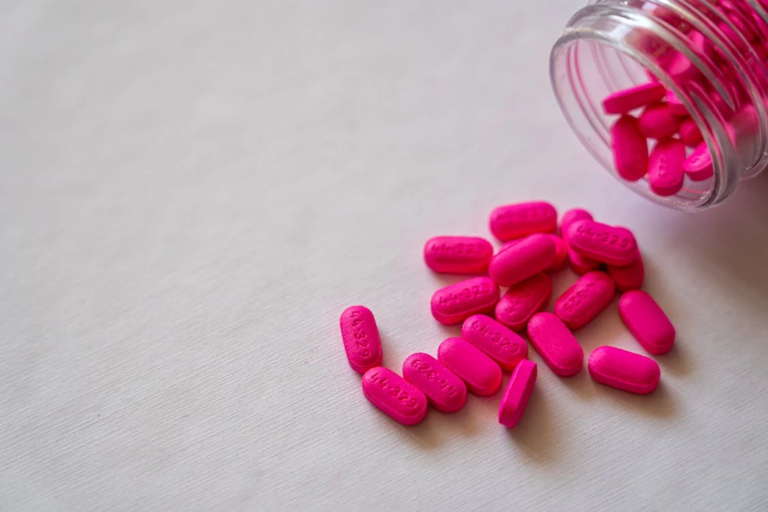pink medication pills on a white surface